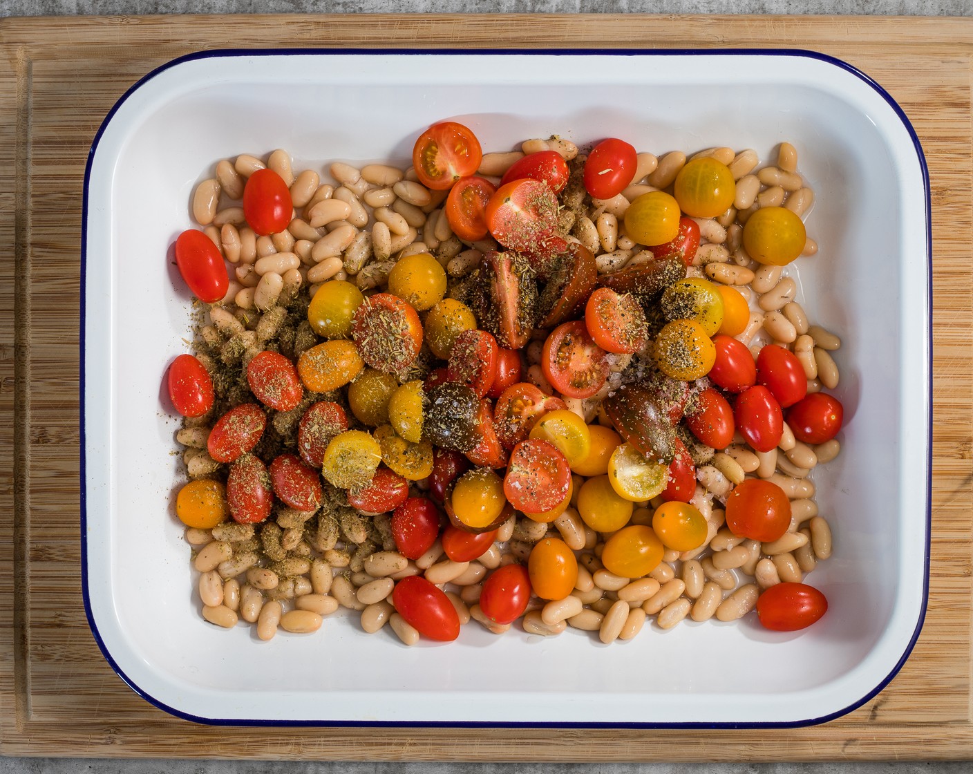 step 2 Put the White Beans (2 cans) and Cherry Tomatoes (2 pckg) into a 9x13-inch deep baking dish and sprinkle with the Italian Seasoning (1 tsp), Kosher Salt (1/2 tsp), and Ground Black Pepper (1/2 tsp). Add ⅓ cup water to the pan and gently mix everything together.