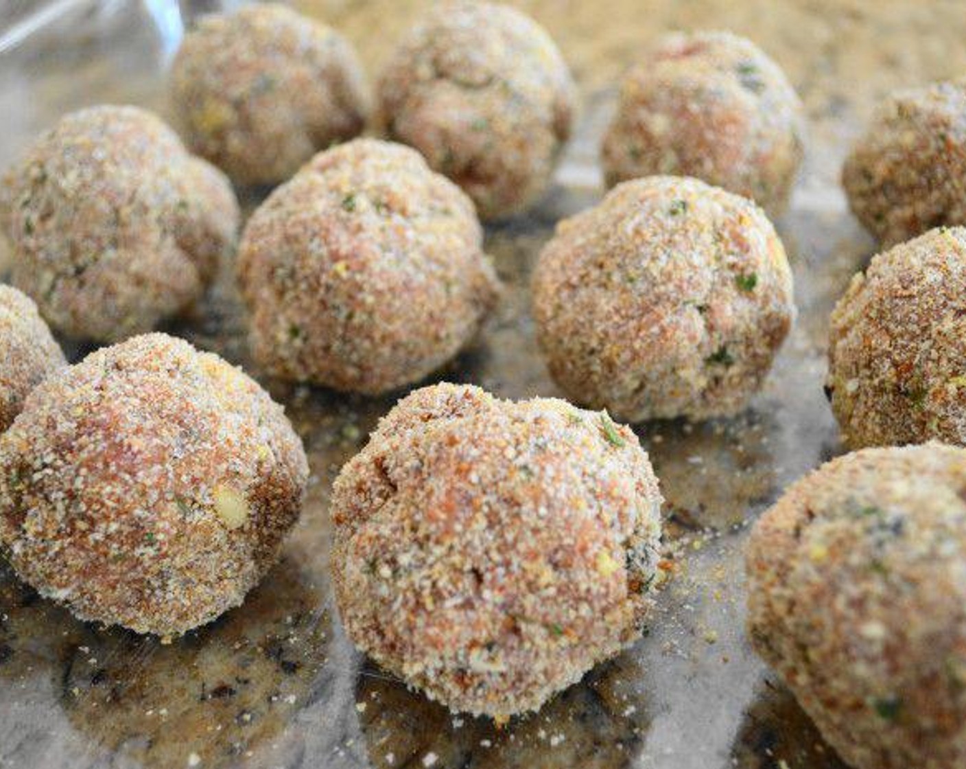 step 3 Gently work the mixture together with your clean hands. Take a small amount of the mixture about the size of your palm and roll it into a ball. Roll it in Breadcrumbs (1 cup), then place it in the baking dish. Repeat with the remaining mixture until you have 12-13 meatballs.