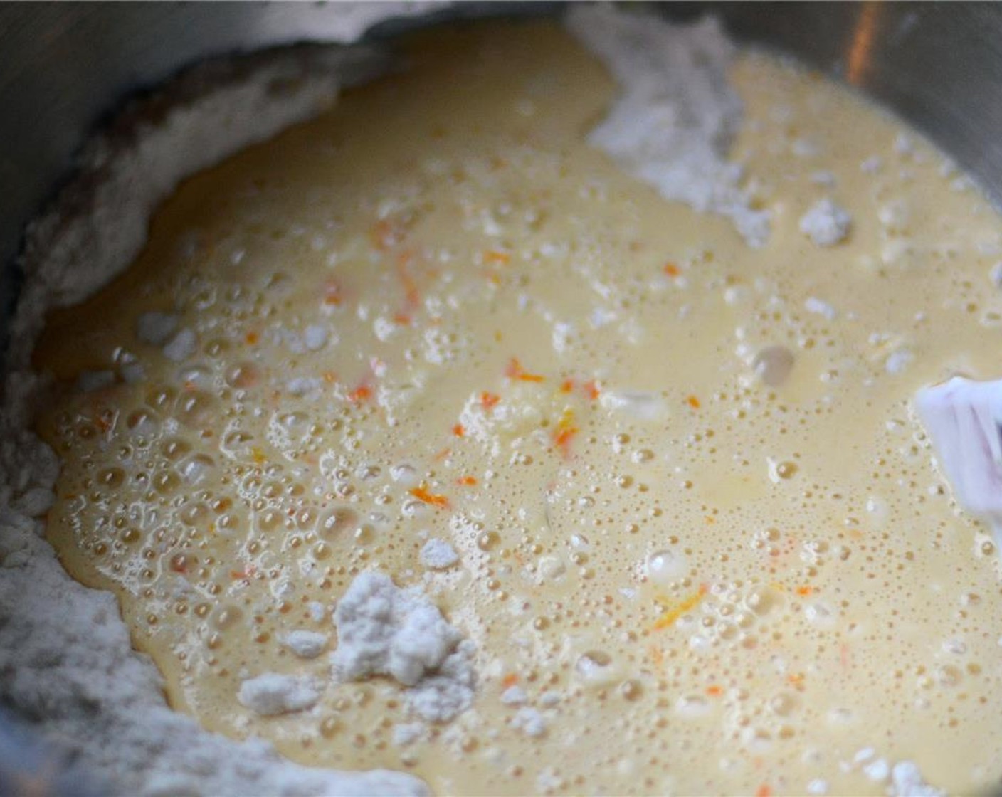 step 4 In a medium-sized bowl, whisk together the zest and juice from the Oranges (3), Eggs (2), Sour Cream (1/3 cup), and Vanilla Extract (1/2 Tbsp). Pour into the flour mixture and mix gently until just combined.