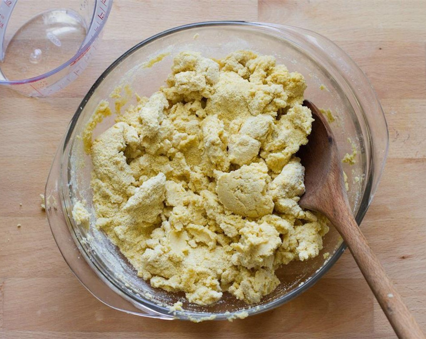 step 3 Continue mixing the dough with your hands and knead it in the bowl for about 2 minutes until you can form a ball that is not sticky or crumbly. Add more Water (2 cups) 1 tbsp at a time to help form the dough.