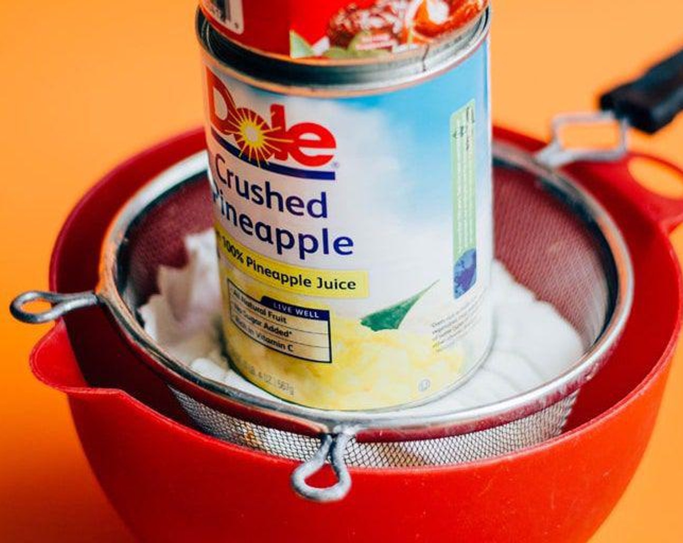 step 2 Set strainer over a large bowl and place a heavy can or two on top to help squeeze out the whey liquid.