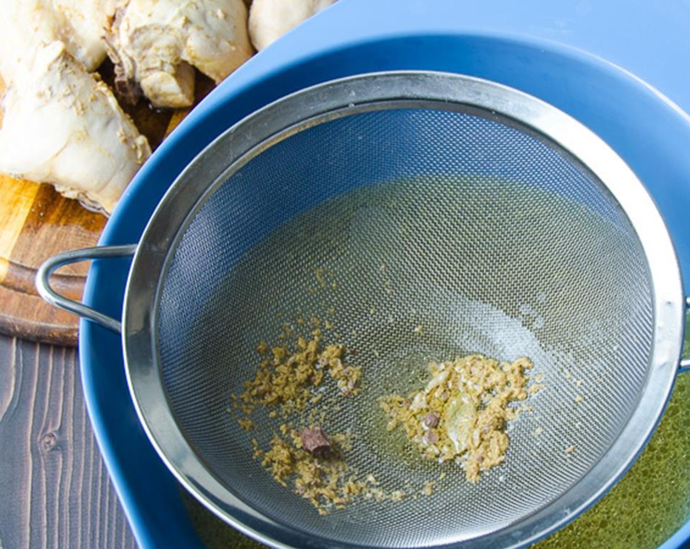 step 6 Set a fine mesh sieve over a large bowl and pour the broth through the sieve to remove the bouquet garni and any gray matter or other scum. Discard.