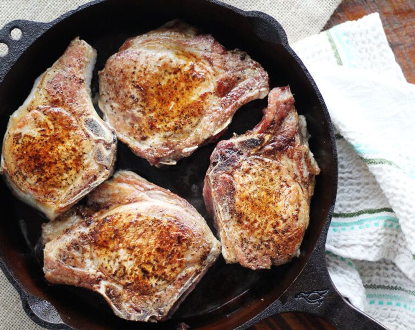 step 5 When the oil starts to shimmer and smoke slightly, place the pork chops into the skillet. Let them cook for approximately 2 minutes per side or until golden brown, turning once. Reduce heat if needed to prevent burning.