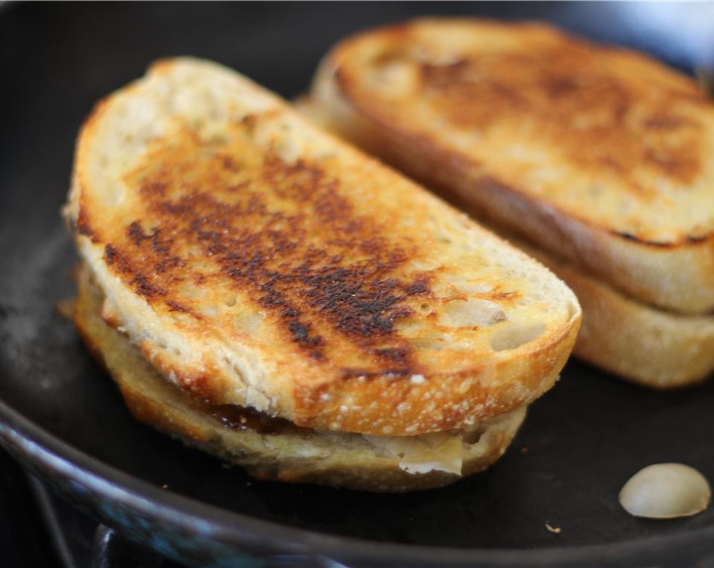 step 5 Place the sandwich on the skillet and press down with a spatula. Grill for about 5 minutes, or until the bread is turning golden brown and the cheese is melting. Flip the sandwich and continue cooking until the cheese is melted.