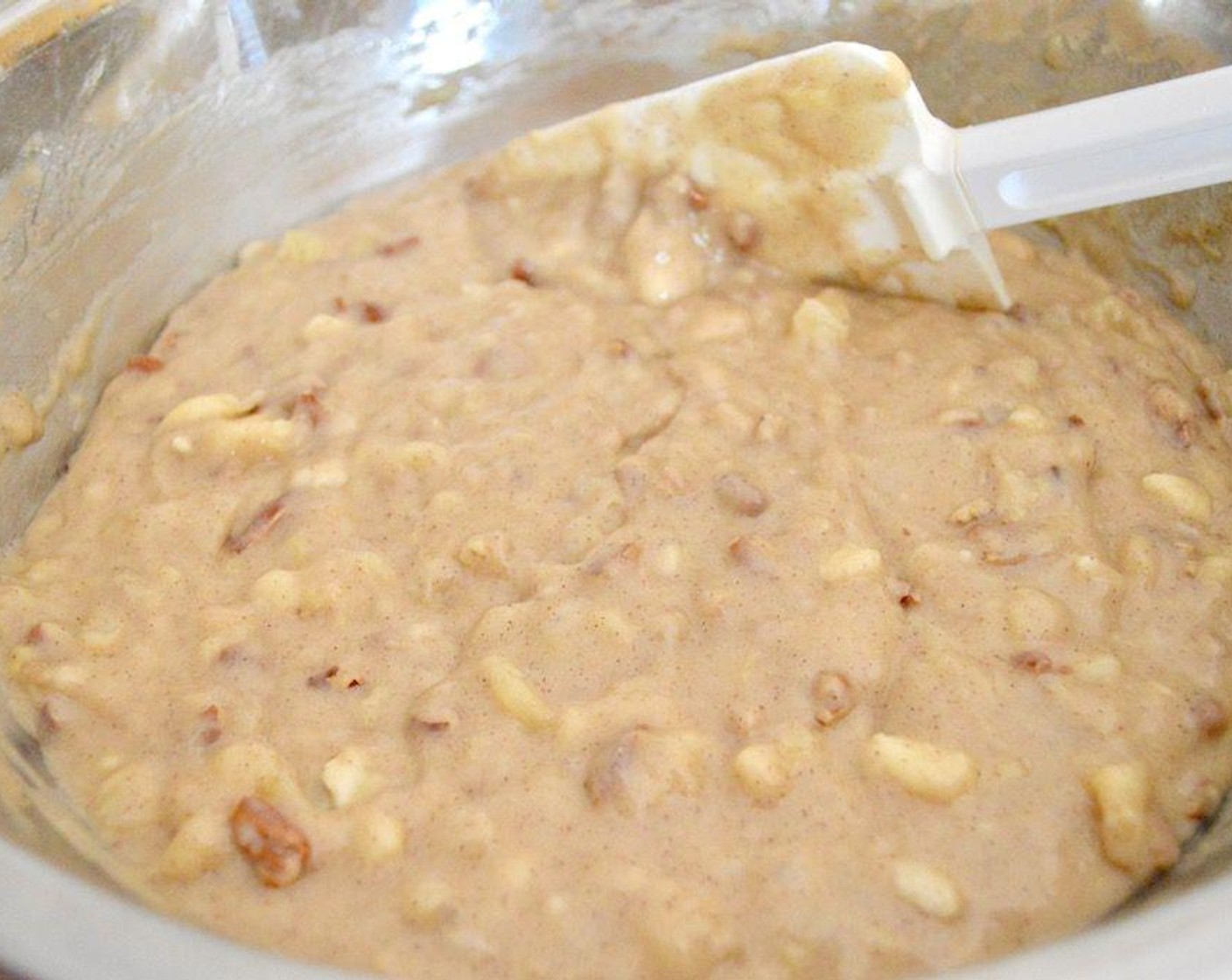 step 4 Stir the Bananas (4), Crushed Pineapple in 100% Pineapple Juice (1 cup), Vegetable Oil (1 cup), Eggs (2), Vanilla Extract (1/2 Tbsp), and Chopped Pecans (1 cup) together in another bowl thoroughly, then pour it into the bowl of dry ingredients.