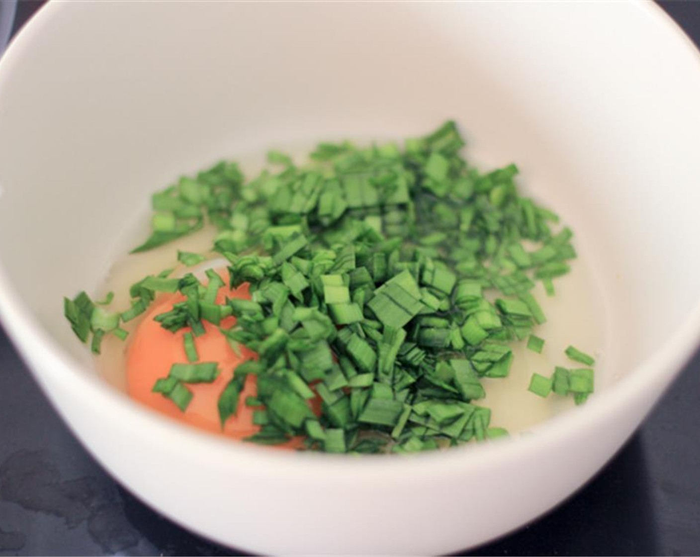 step 1 Crack an Egg (1) into a bowl, add Salt (to taste), Ground Black Pepper (to taste), and Fresh Chives (3 stalks), and mix well.