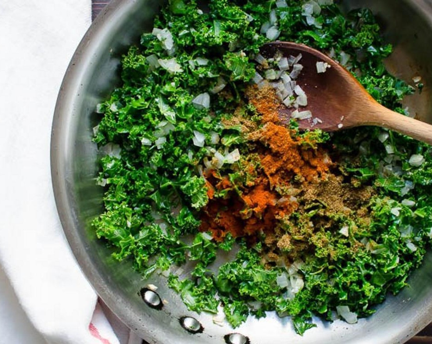 step 4 In a large skillet, heat one tablespoon of Olive Oil (1 Tbsp) over medium-high heat. Add the Onion (1) and saute for one to two minutes until slightly softened. Add the Garlic (2 cloves) and Kale (2 cups). Cook until the kale is wilted