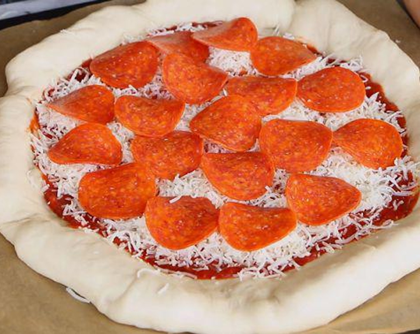step 4 Spoon the sauce onto the dough. Sprinkle the Mozzarella Cheese (1 cup) and Pepperoni Slices (to taste) on top. Bake for 13-15 minutes. Remove the parchment paper and continue cooking until golden on the bottom.