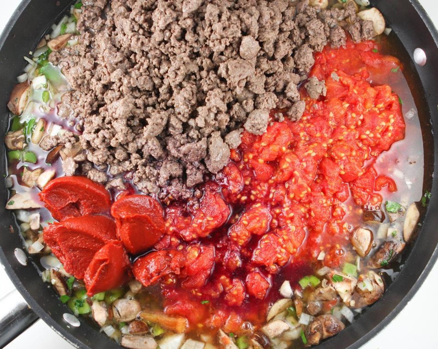 step 4 Add the Crushed Tomatoes (2 cans), Diced Tomatoes (1 can), Tomato Paste (2 cans), Beef Broth (14 fl oz), Red Wine (1/2 cup), Brown Sugar (2 tsp), Italian Seasoning (2 Tbsp), and Salt (1 tsp) to the skillet.