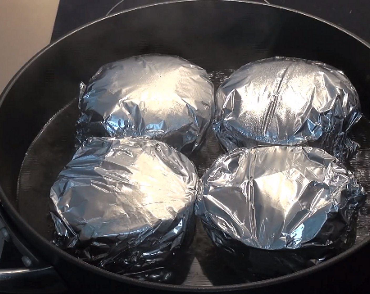 step 6 Place the covered puddings into a large, deep frying or sauce pan. Pour in enough water to reach halfway up the pudding bowls. Bring water to a boil, put on the lid and turn the heat down to low and allow the puddings to steam for an hour.