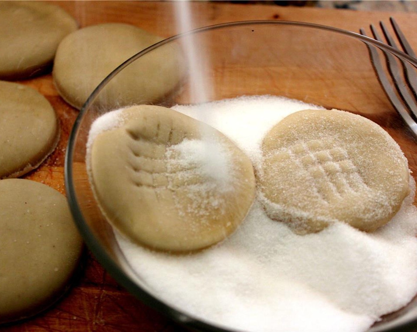 step 4 Dip the cookies in Granulated Sugar (1/2 cup) and coat thoroughly. You can use a fork to make that classic peanut butter cookie imprint design!