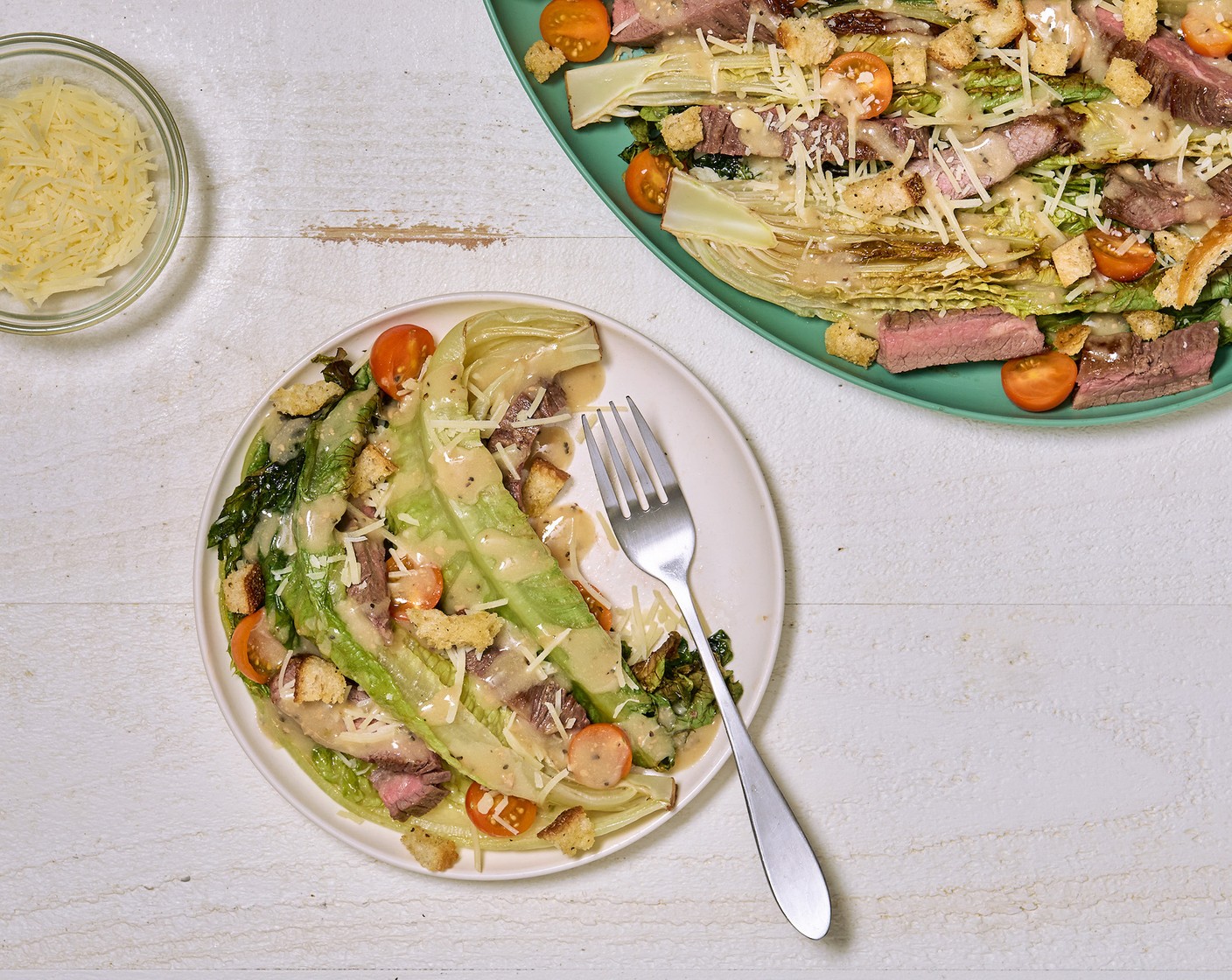 step 6 Plate overtop romaine halves with Cherry Tomatoes (to taste), Shredded Parmesan Cheese (1/4 cup), and Croutons (1 bag). Drizzle with Caesar Dressing (1/2 cup) and toss well to mix. Optionally, serve with Lemons (to taste).