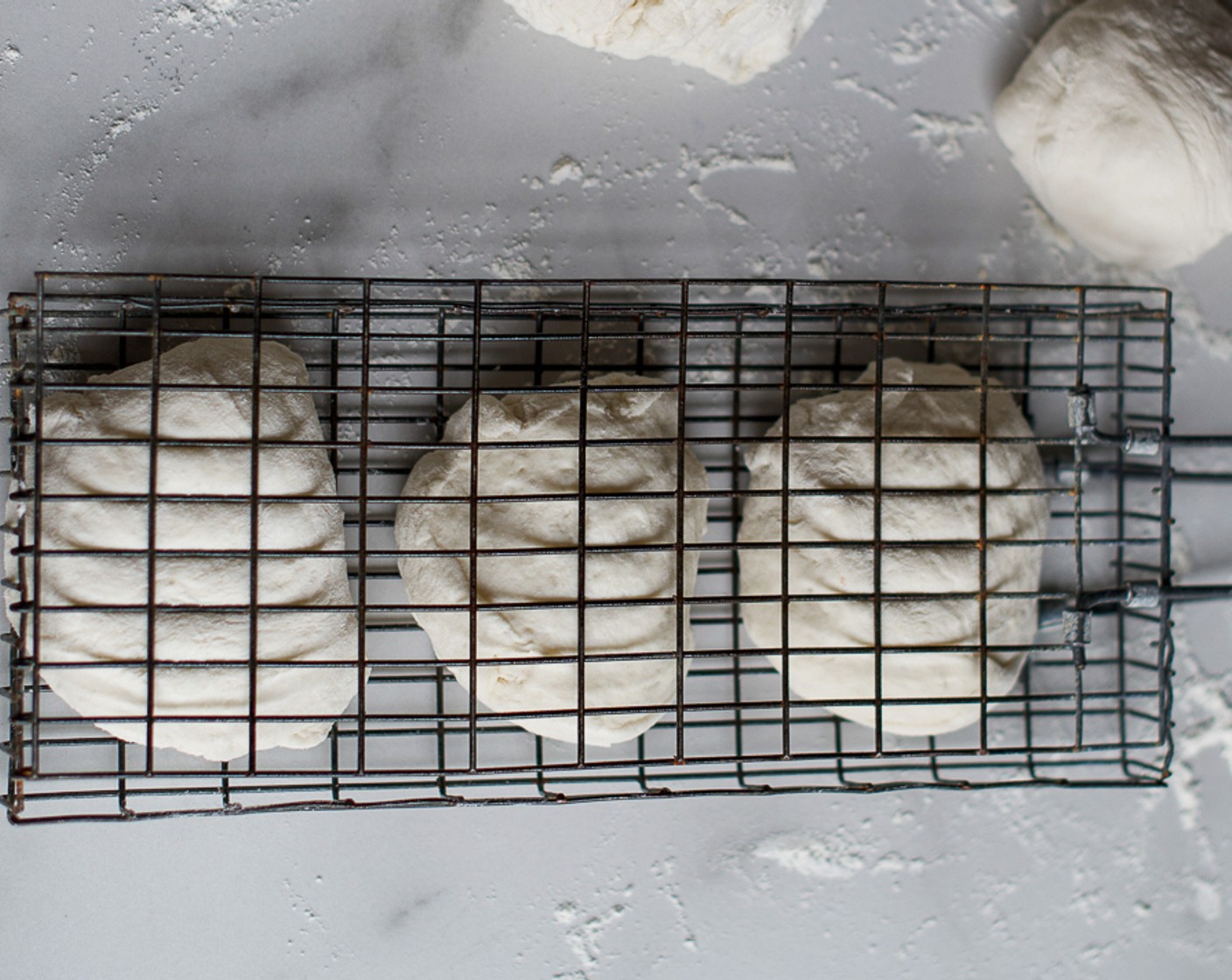 step 4 Grease a hinged grid and braai with Olive Oil (1 1/3 Tbsp). Place the balls on top over medium coals, turning often, until the roosterkoek is cooked through. Keep warm until needed.