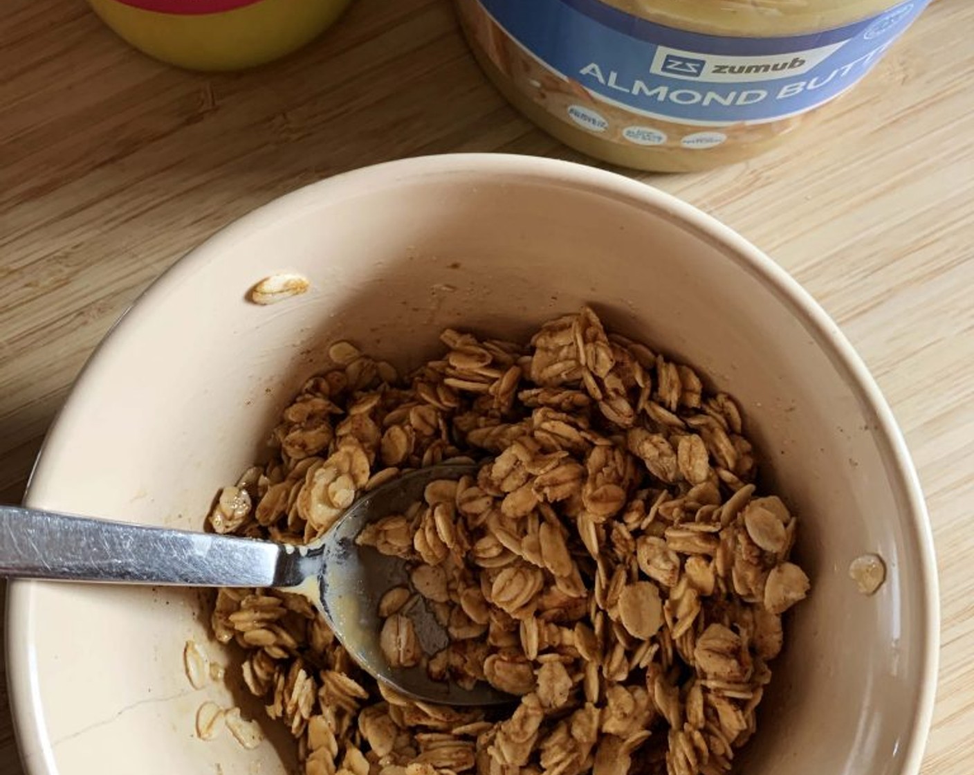 step 7 While the custards are chilling, prepare the granola. This recipe is super simple and hassle-free. In a bowl just stir together Oats (1/2 cup), Almond Butter (1 1/2 Tbsp), Ground Cinnamon (1 dash), and Coconut Ghee (1 Tbsp).