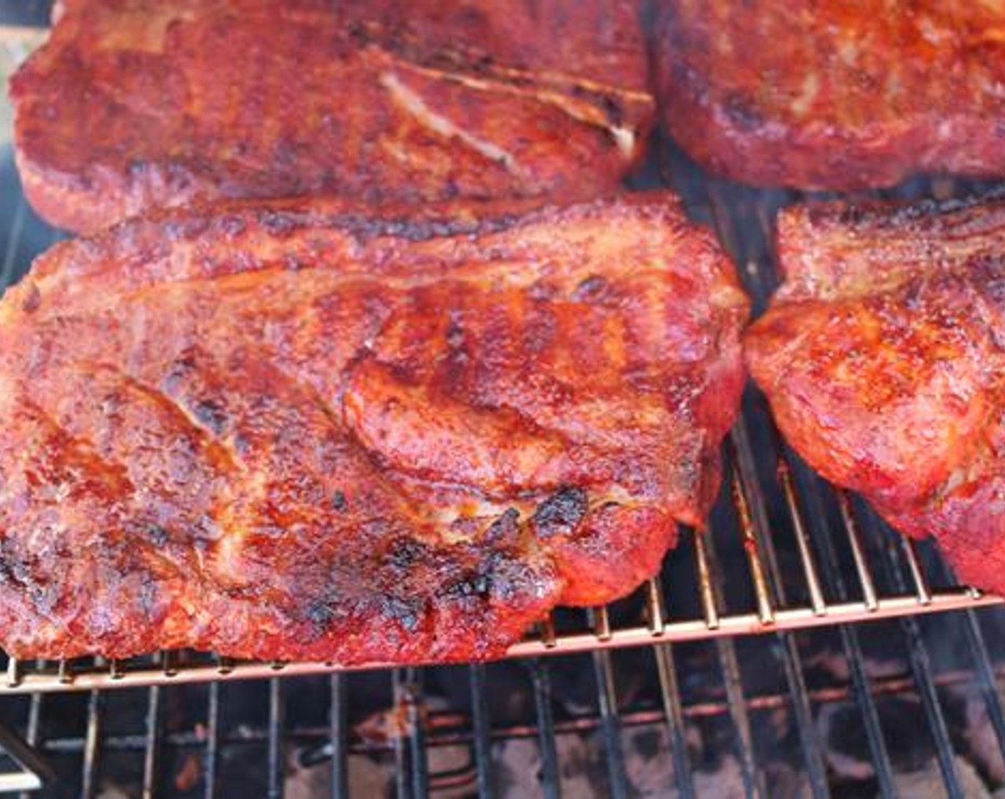 step 3 Place the pork steaks on a raised rack a few inches above the cooking grate. Cook on both sides for 20 minutes each or until the outside begins to darken.