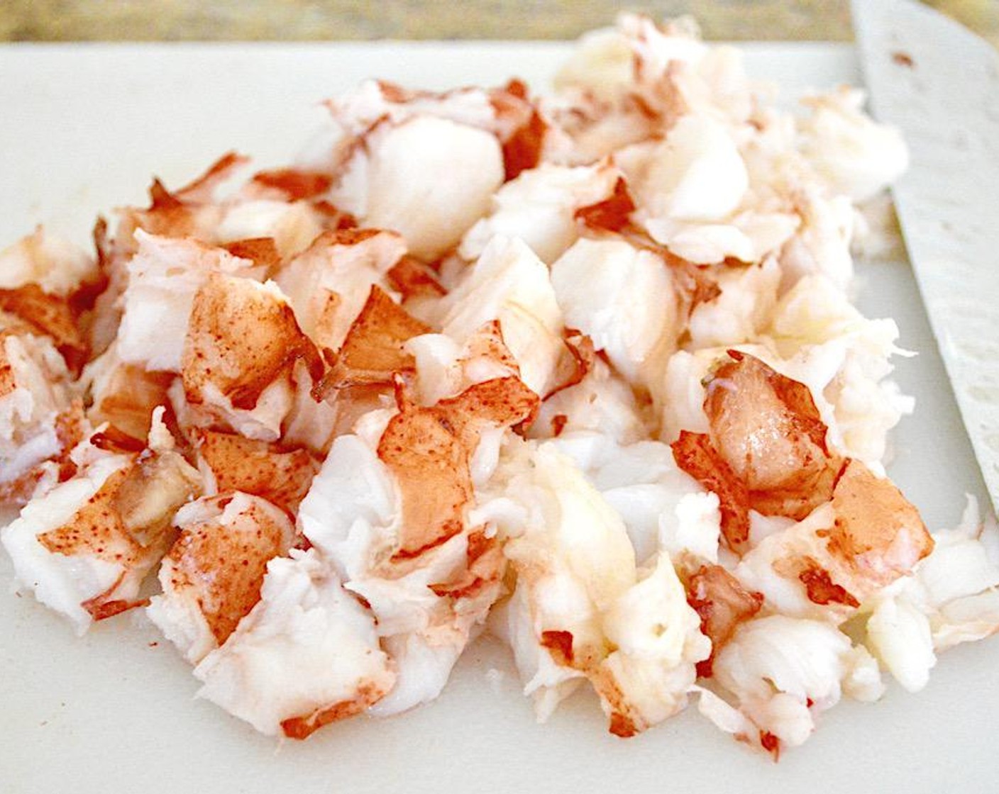 step 2 Remove lobster tails to a cutting board and let them cool enough to handle. Turn off the stove in the meantime and drain the water out of the skillet, but don't clean it out to keep the lobster flavor. Remove the tail meat from the shell and dice it into small, bite sized chunks.