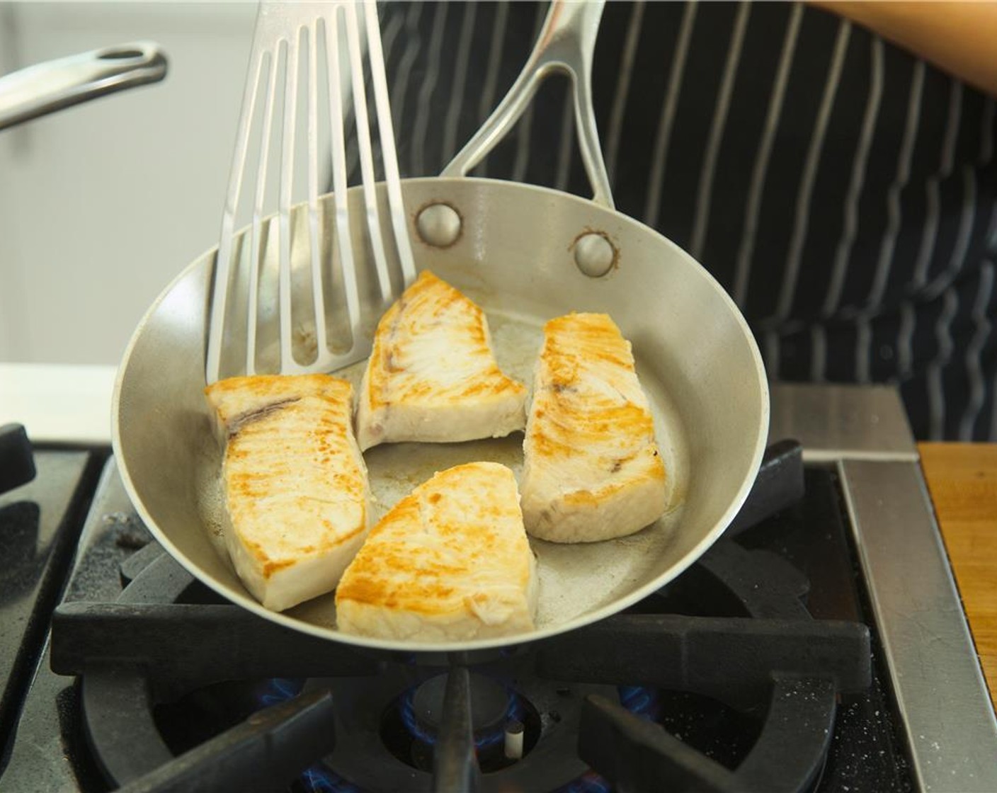 step 13 In a medium saute pan, heat Olive Oil (1 Tbsp) over medium high heat. Once oil is hot, sear fish in saute pan for four minutes until golden brown on one side.