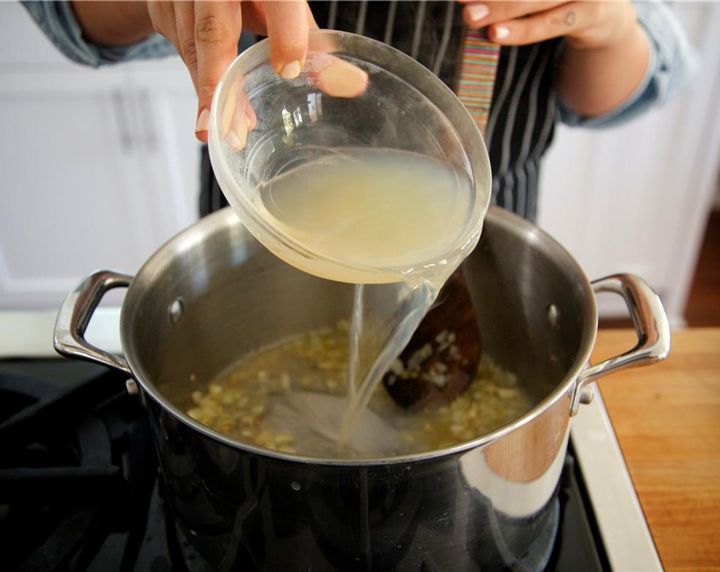 step 16 Add White Cooking Wine (1/2 cup), Clam Juice (1/2 cup), half a cup of water, and bring to a boil.