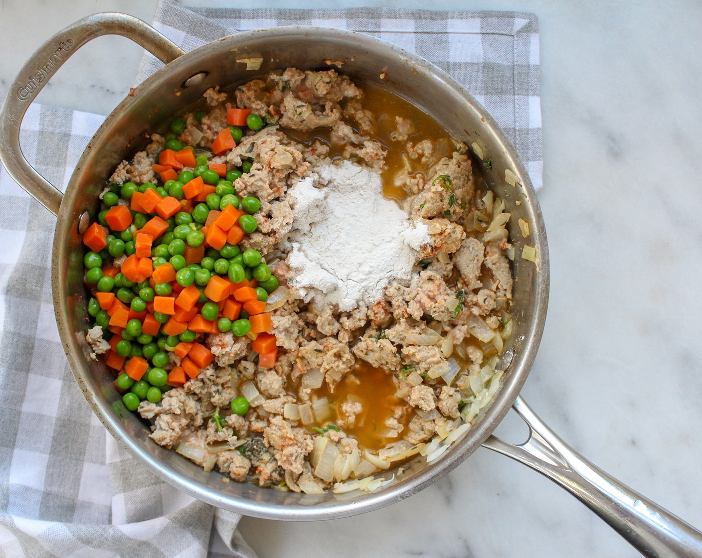 step 2 Add All-Purpose Flour (2 Tbsp), Chicken Broth (1 cup), and Frozen Peas and Carrots (1 cup). Bring to a simmer for about 5 minutes.