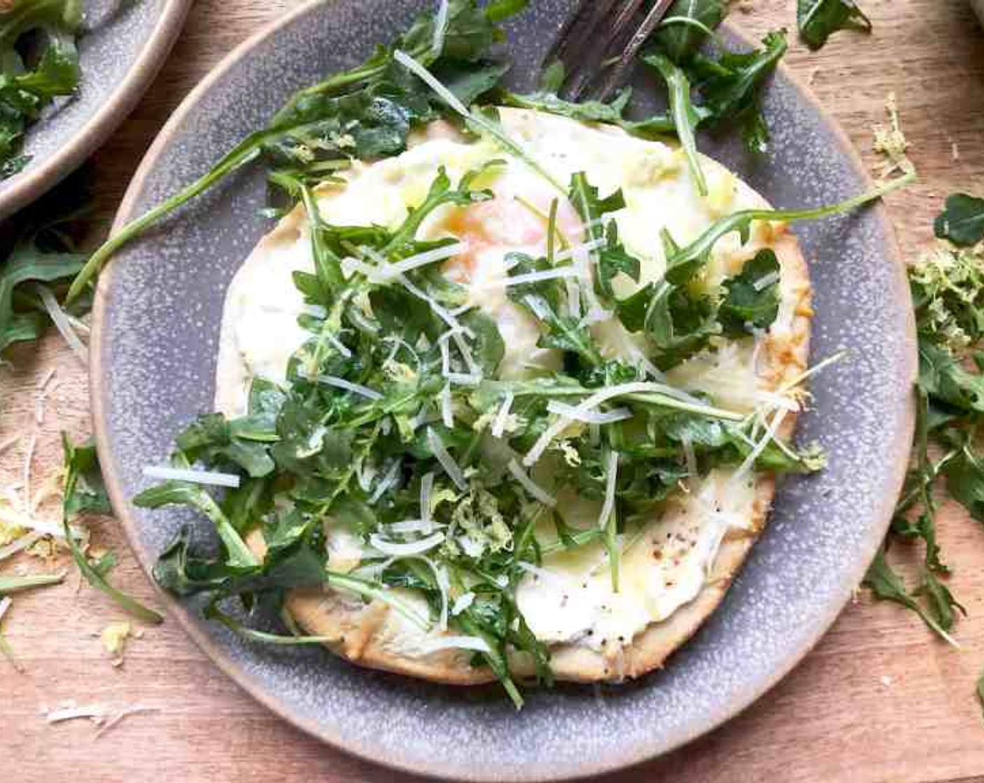 step 10 Top each cooked pizza with about 1 cup dressed arugula. If desired, sprinkle a small amount of additional grated Parmesan over each along with a bit of lemon zest. Serve immediately.