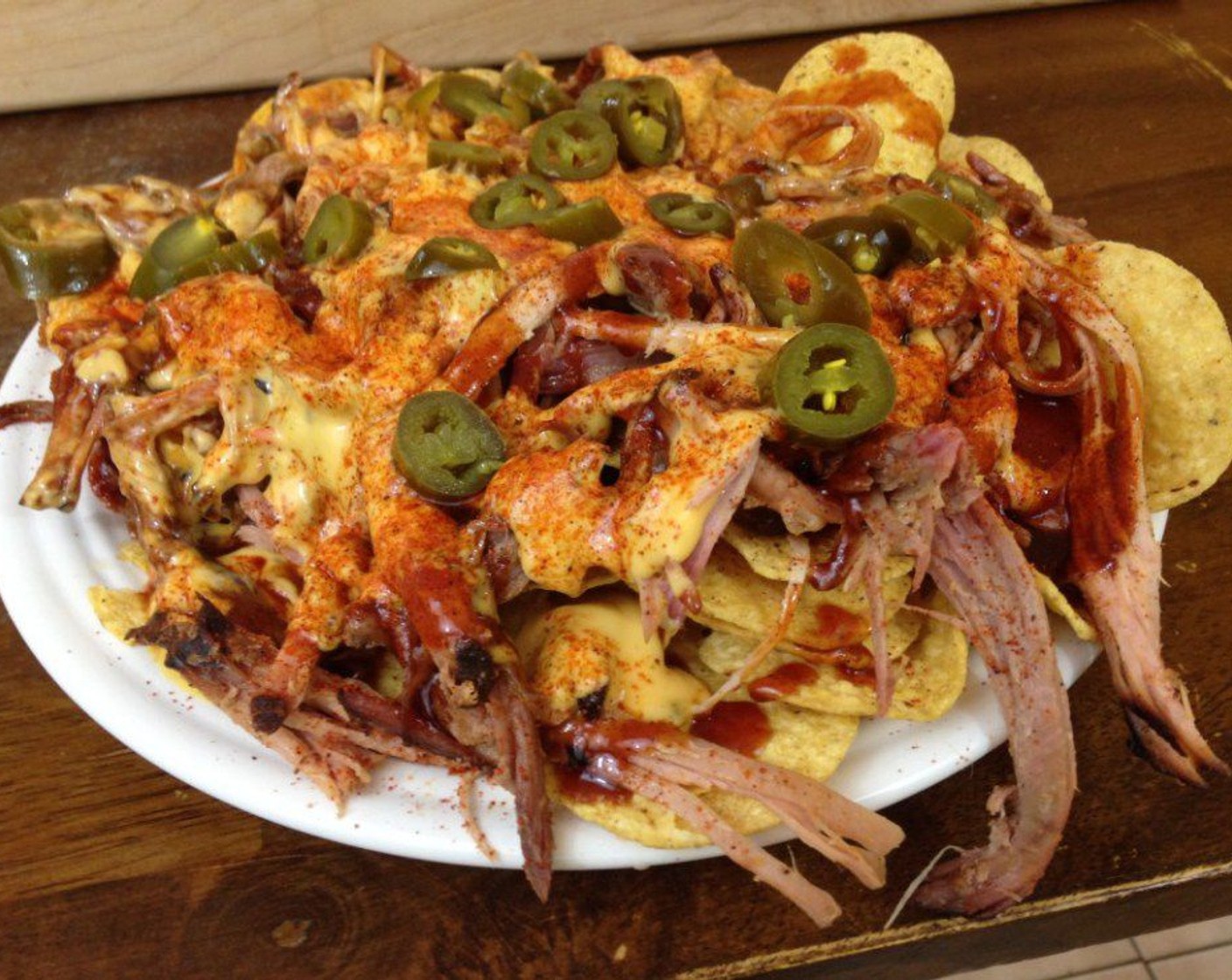 step 8 To assemble your barbecue nachos, start with a good layer of Tortilla Chips (to taste). Then add your BBQ Pulled Pork, Barbecue Sauce (to taste) and a good layer of Nacho Cheese (to taste) dip. To top it all off you sprinkle your favorite Barbecue Rub and add as many Jalapeño Peppers (to taste) as you like.