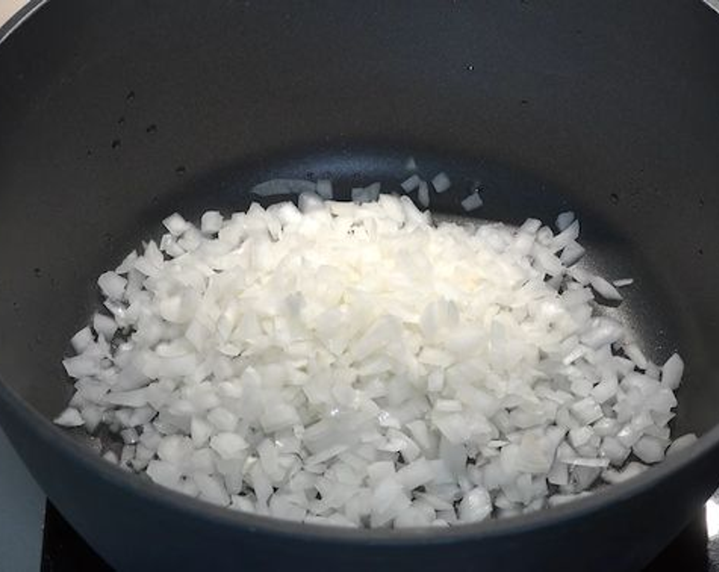 step 1 Place a large pot on your stove over medium-high heat. Add in some Vegetable Oil (as needed), Yellow Onion (1), Garlic (2 cloves) and cook for a couple of minutes or until the onions start to soften slightly.