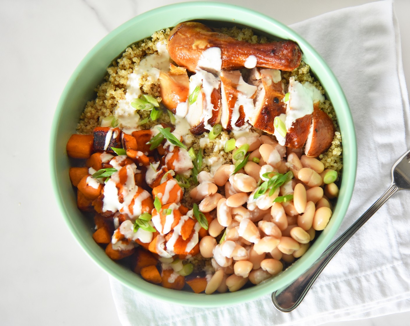 step 7 Divide the quinoa among four bowls or plates. Top each with an equal amount of sweet potato, Cannellini White Kidney Beans (1 can), and Rotisserie Chicken (1). Drizzle some of the feta sauce over the top and sprinkle with Scallions (to taste), if desired.