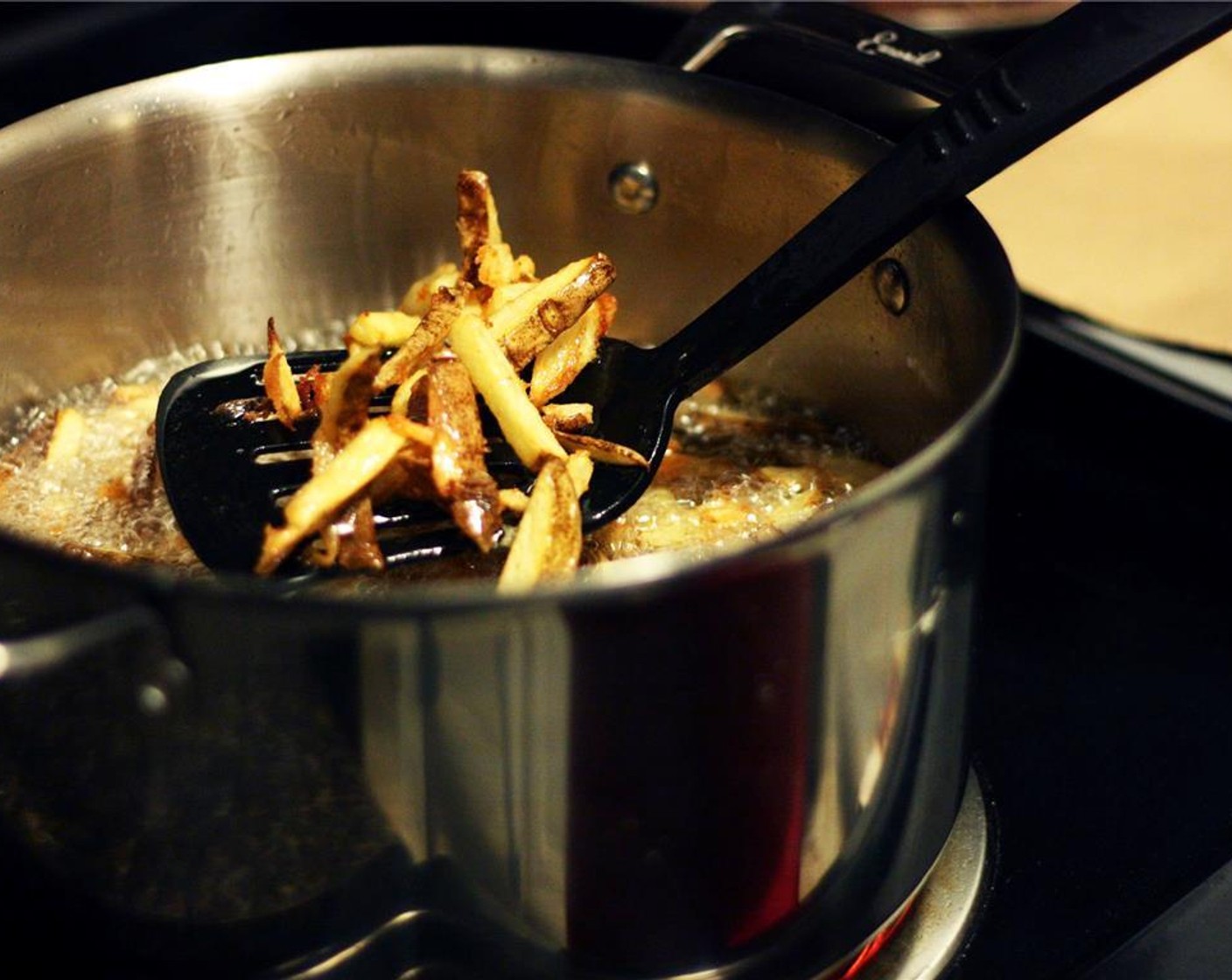 step 8 Working quickly to avoid burning them, lift the fries from the oil with a slotted spatula or spoon and dump them on the paper-lined cookie sheet. Once all fries are out of the oilf, turn off the heat and allow the oil to cool.