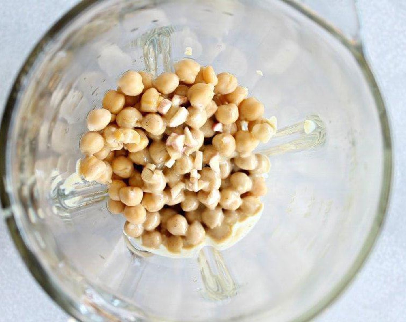 step 3 Place the canned chickpeas, Tahini (3 Tbsp), Olive Oil (2 Tbsp), Coconut Milk (120 mL), and garlic in a blender and blend until smooth and creamy.
