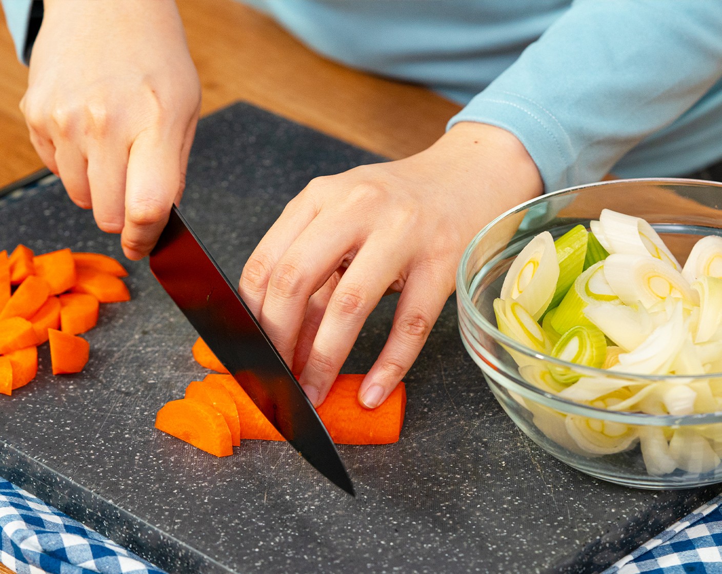 step 2 Cut the Carrot (1) in half lengthwise, then diagonally slice into 1/4-inch thick slices. Cut the white and light green part of the Leek (1) diagonally into about 1/2-inch slices. And slice the Yellow Onion (1/2) into 1/4-inch thick.