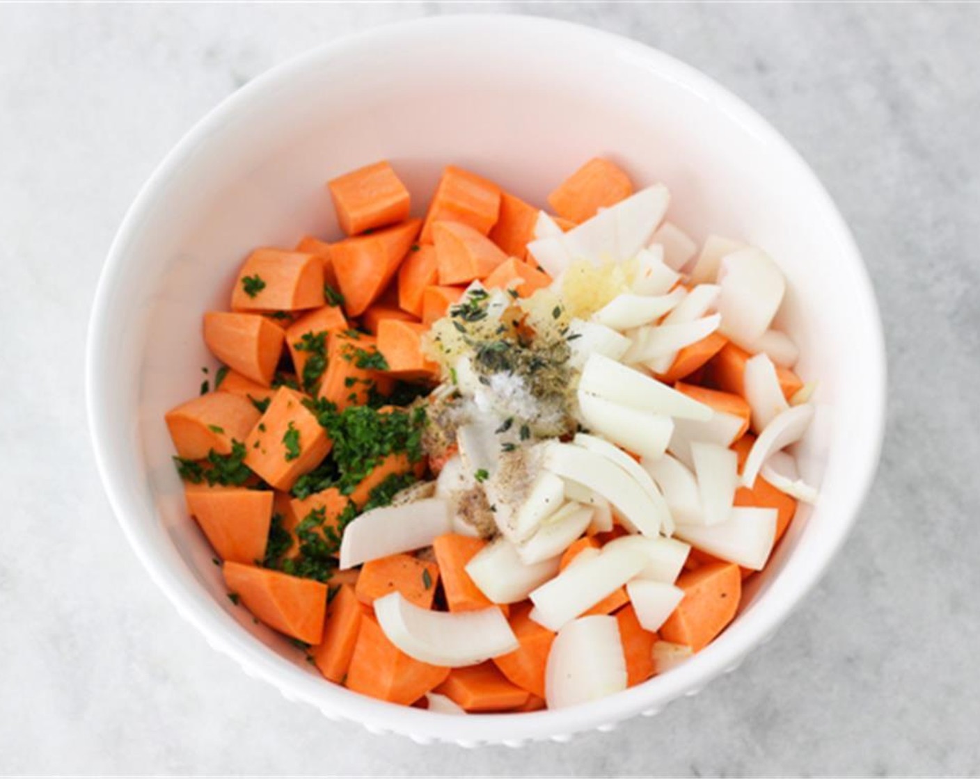 step 5 In a large bowl, combine the sweet potatoes, onion, garlic, Dried Mixed Herbs (1 Tbsp), fresh herbs, Olive Oil (2 Tbsp), Maple Syrup (1 Tbsp), and Salt (1/2 tsp) and Ground Black Pepper (1/2 tsp).