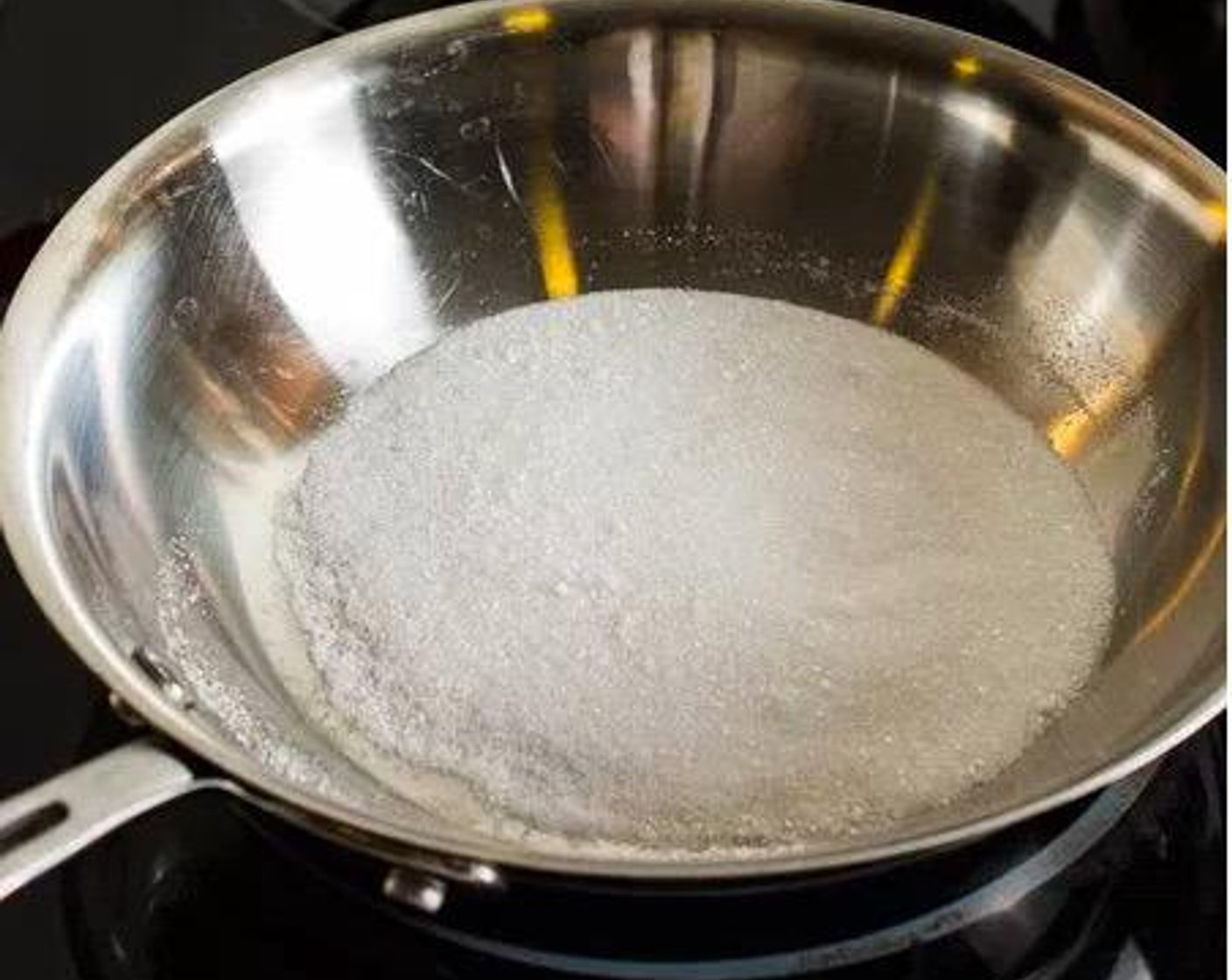 step 5 Pour the remaining 3 tablespoons of sugar in a small frying pan and set it over the medium-high heat. Allow the sugar to melt and caramelize. Use a heat-resistant silicone spatula to gently stir the caramel.