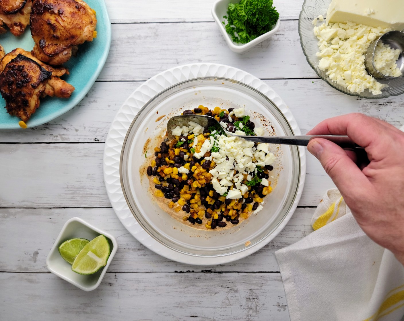 step 9 Add the roasted corn and black beans to the dressing and mix gently until coated evenly with the dressing. Top the corn and black bean salad with the crumbled Queso Fresco (1 cup) and then garnish with more Fresh Parsley (1 Tbsp). Serve with lime wedges.