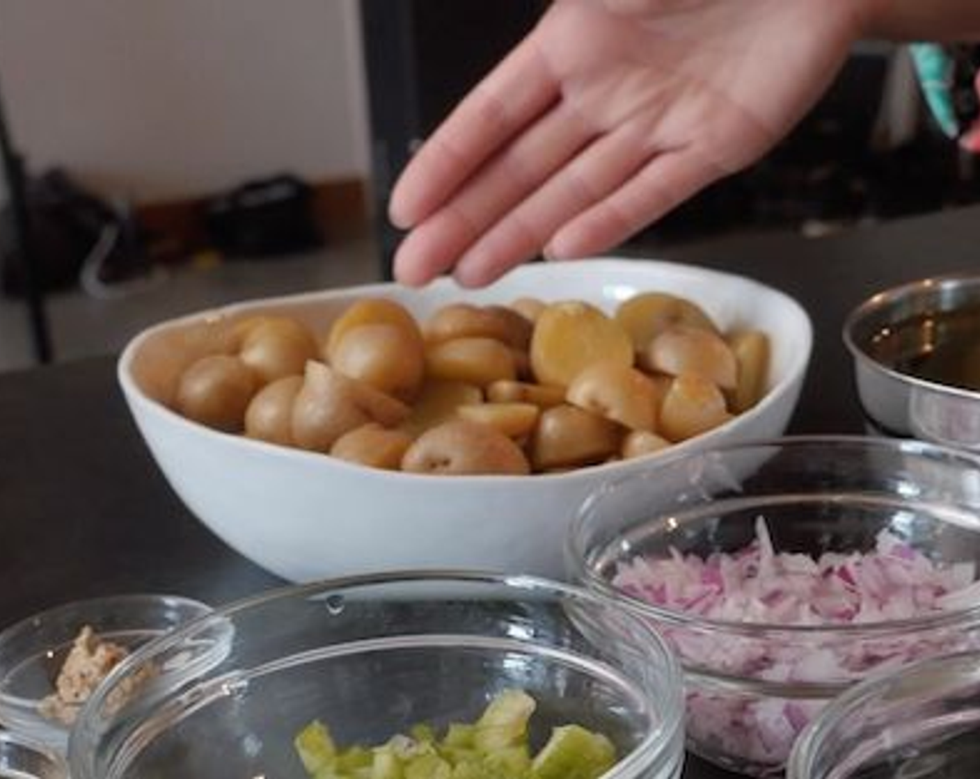 step 2 Once cooked, drain the potatoes and immediately transfer to a large bowl. Cover the bowl with plastic wrap, but leave an edge open to allow heat to escape. Pop the boiled potatoes into the fridge to chill. Once chilled, cut them in half before mixing into the rest of the salad.