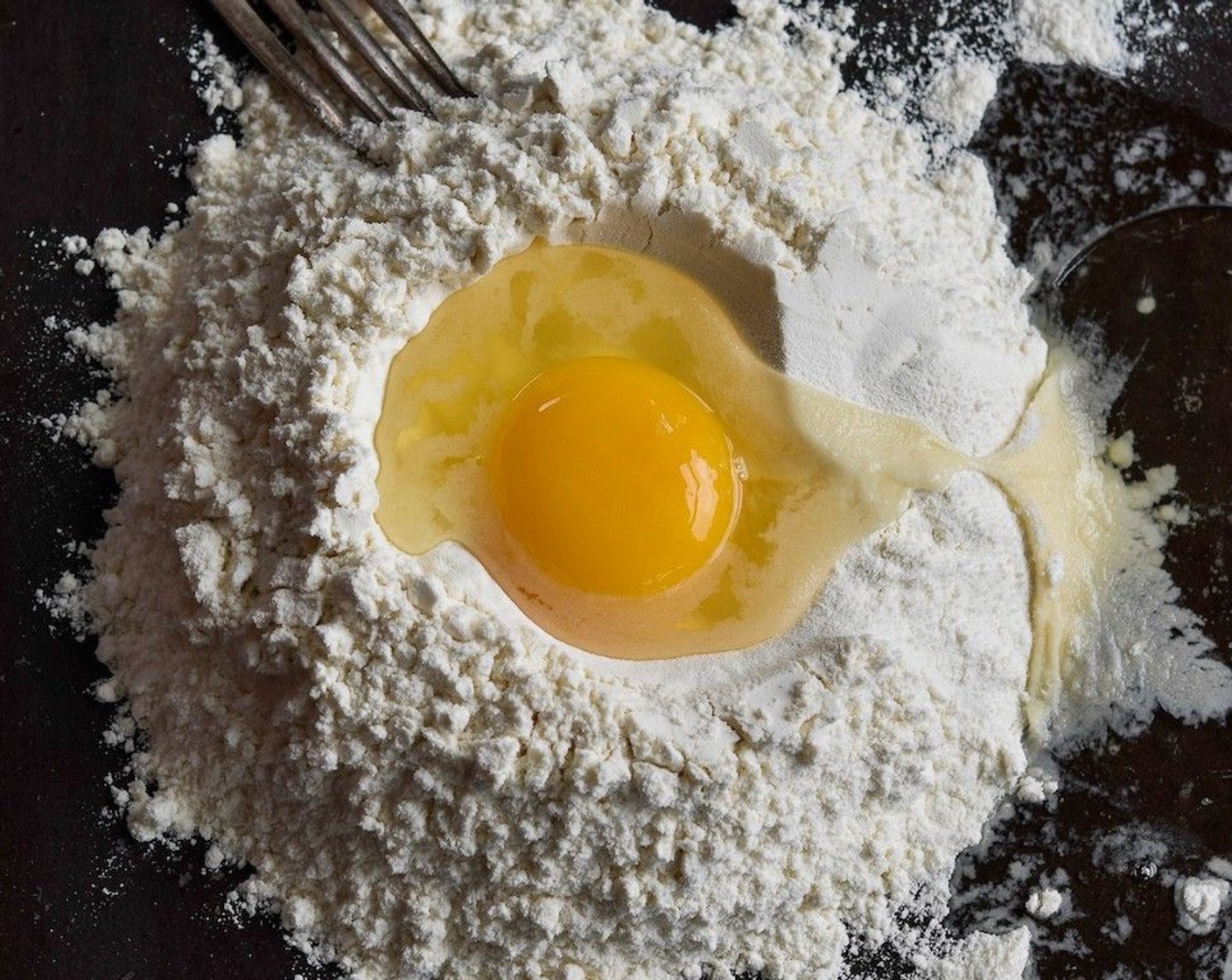 step 5 Sift the Type 00 Flour (3 cups) and add a pinch of Salt. On a flat surface, turn out the flour and make a well in the center. Pour in the Eggs (4) and, using a fork, work into the flour, eventually making a sticky dough