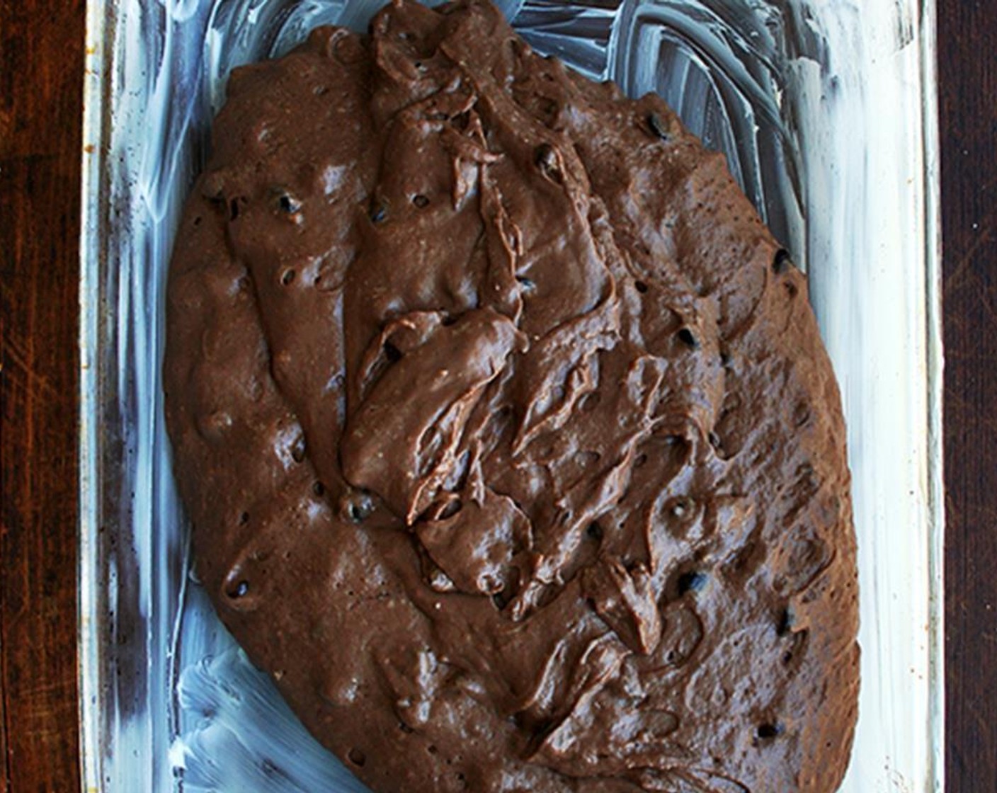 step 5 Pour melted chocolate and butter into dry ingredients. Pour in buttermilk and Vanilla Extract (1 tsp). Stir until combined. Stir in Semi-Sweet Chocolate Chips (1 cup), if desired. Spread into the prepared pan.