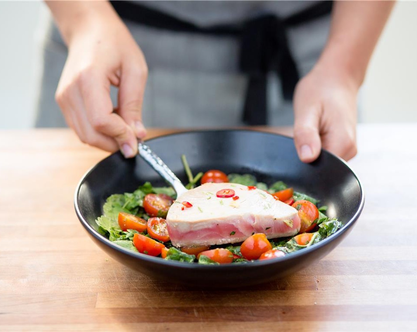 step 9 In the center of two plates, place the watercress salad. Top with seared ahi tuna.