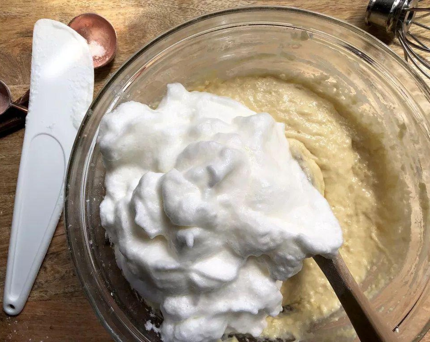 step 4 Place the egg whites into a clean bowl and beat with a wire whisk, or electric mixer, until stiff peaks form. Gently fold the beaten egg whites into the batter with a large spoon.