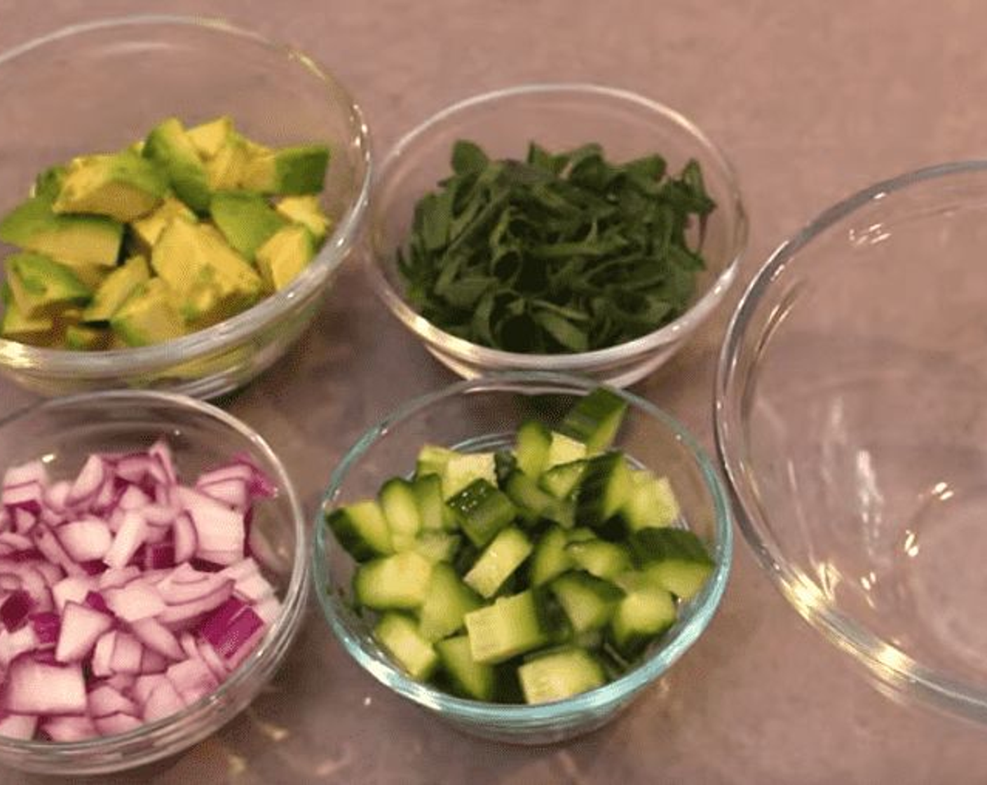 step 1 Into a mixing bowl, add Avocados (4), Red Onion (1/2 cup), Cucumbers (4 Tbsp), and Spring Onions (4 Tbsp).