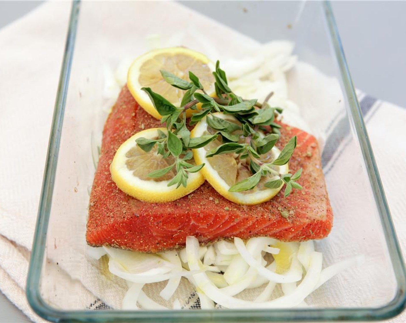 step 3 Arrange the sliced lemon and Fresh Oregano (2 sprigs) on top of the fish. Pour the Olive Oil (2 Tbsp) over the fish, allowing it to coat the onions on the bottom of the pan. Let stand 15-20 minutes at room temperature.