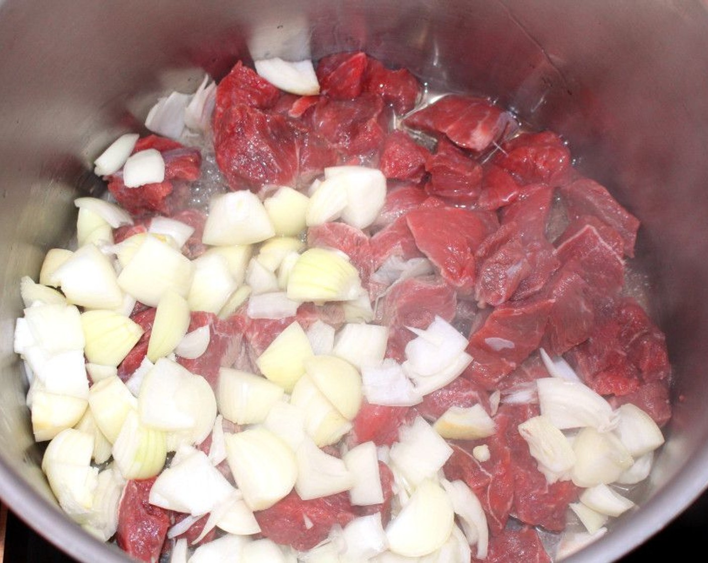 step 3 In a large pot, heat up Vegetable Oil (1/2 cup) then sauté Beef Top Round (2 lb) and Onions (3).
