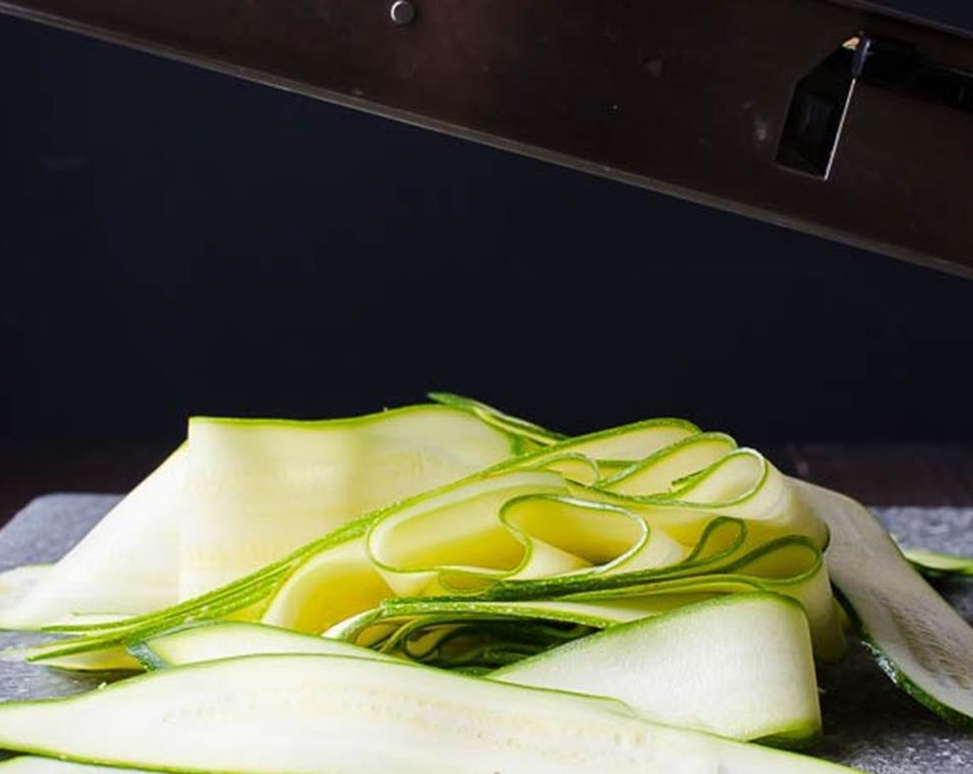 step 3 Using a vegetable peeler or a mandoline, set on very thin slices to slice the Zucchini (1) into thin ribbons and transfer to a large bowl.