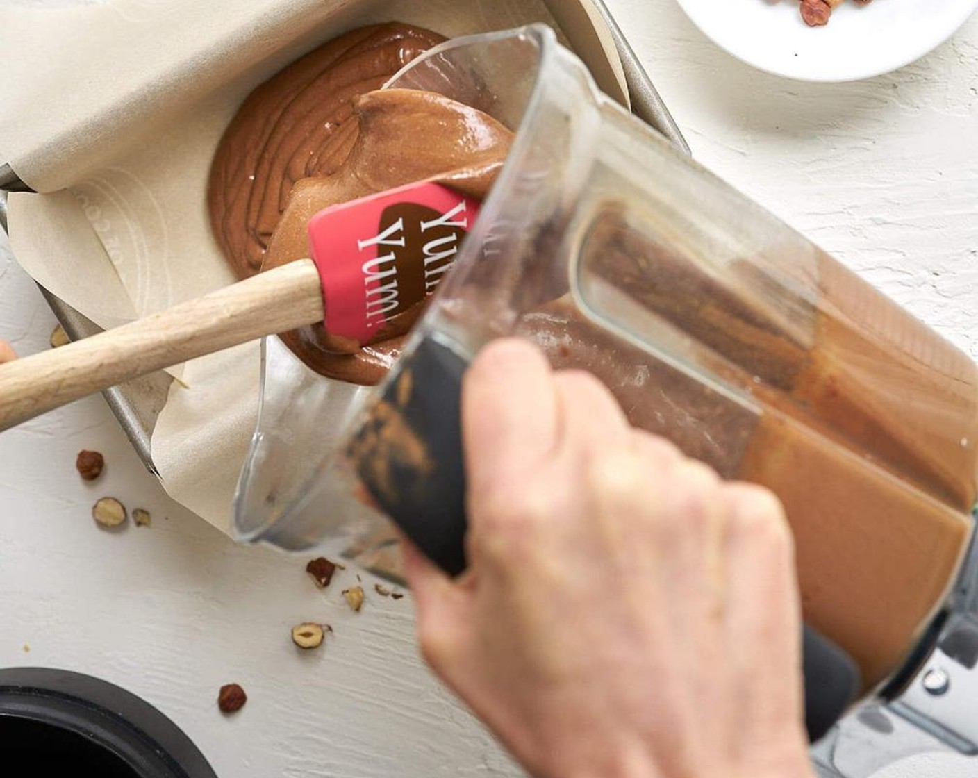 step 2 Line a loaf pan with parchment paper. Pour into loaf pan. Top with Hazelnuts (4 Tbsp). Freeze for 3 to 4 hours until totally solid.