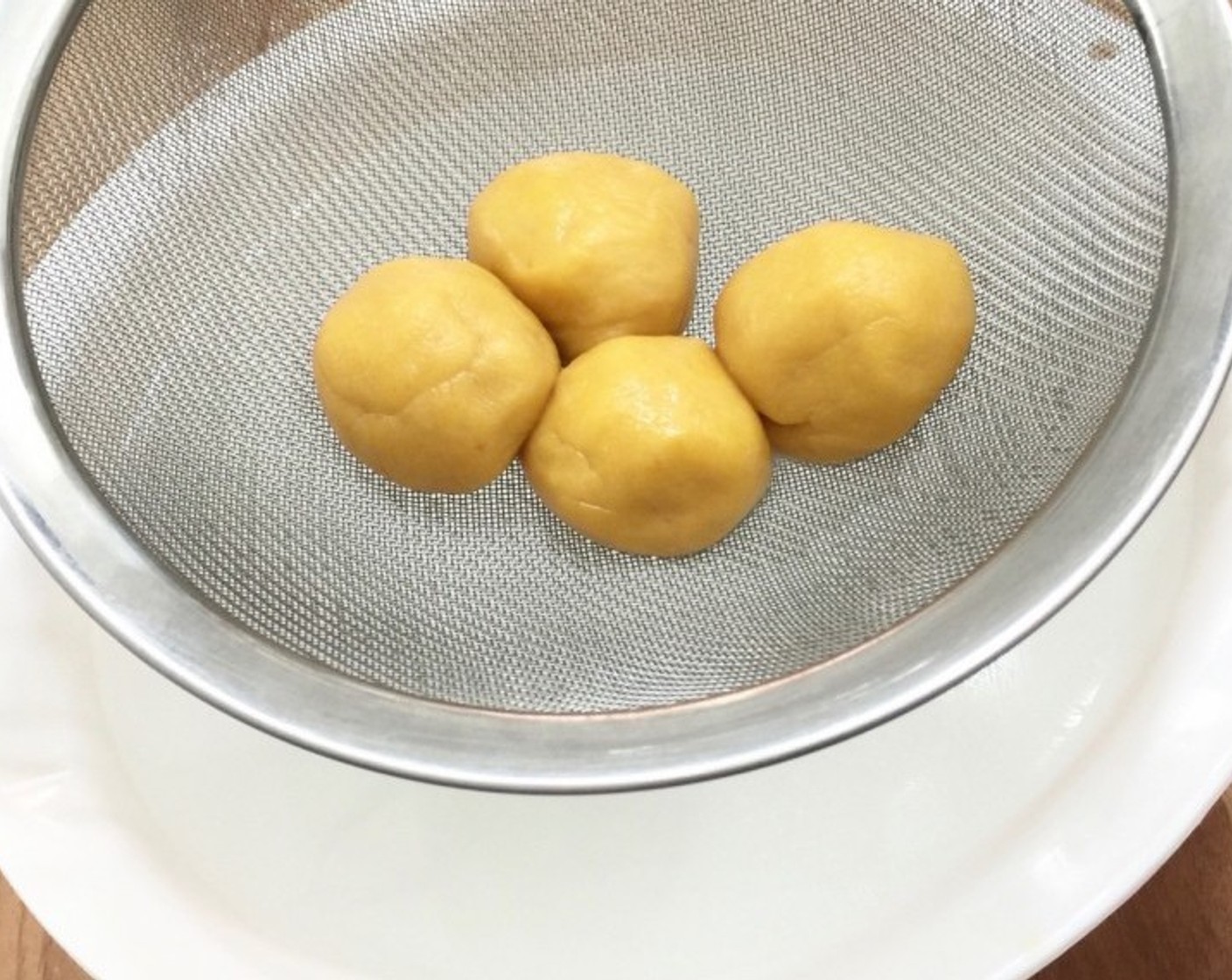 step 12 In batches, place the rolled balls into a sieve and dip them briefly into cold water.