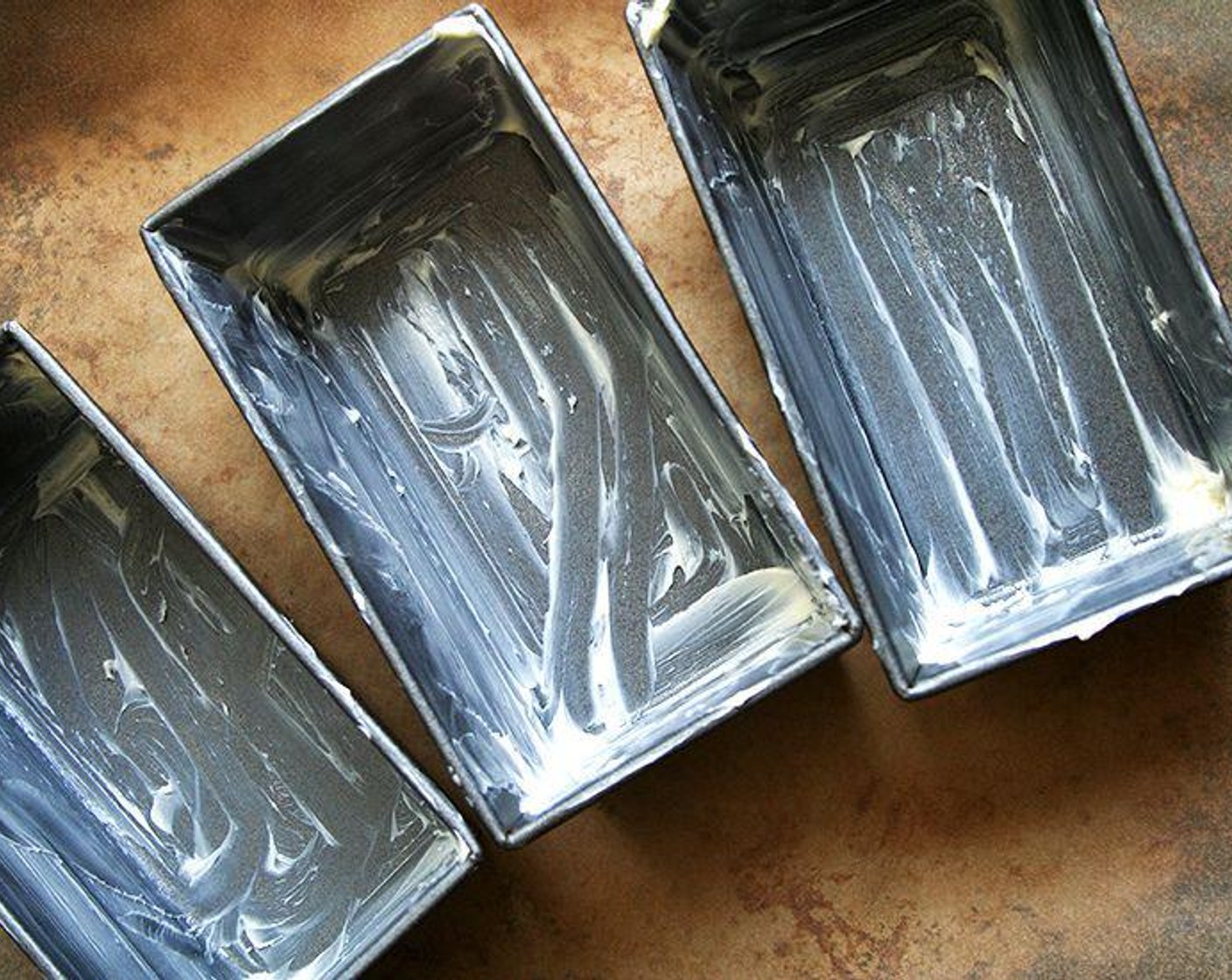step 1 Preheat the oven to 350 degrees F (180 degrees C). Grease a 9x5x3-inch loaf pan or 3 three mini loaf pans with butter (grease pans very well).