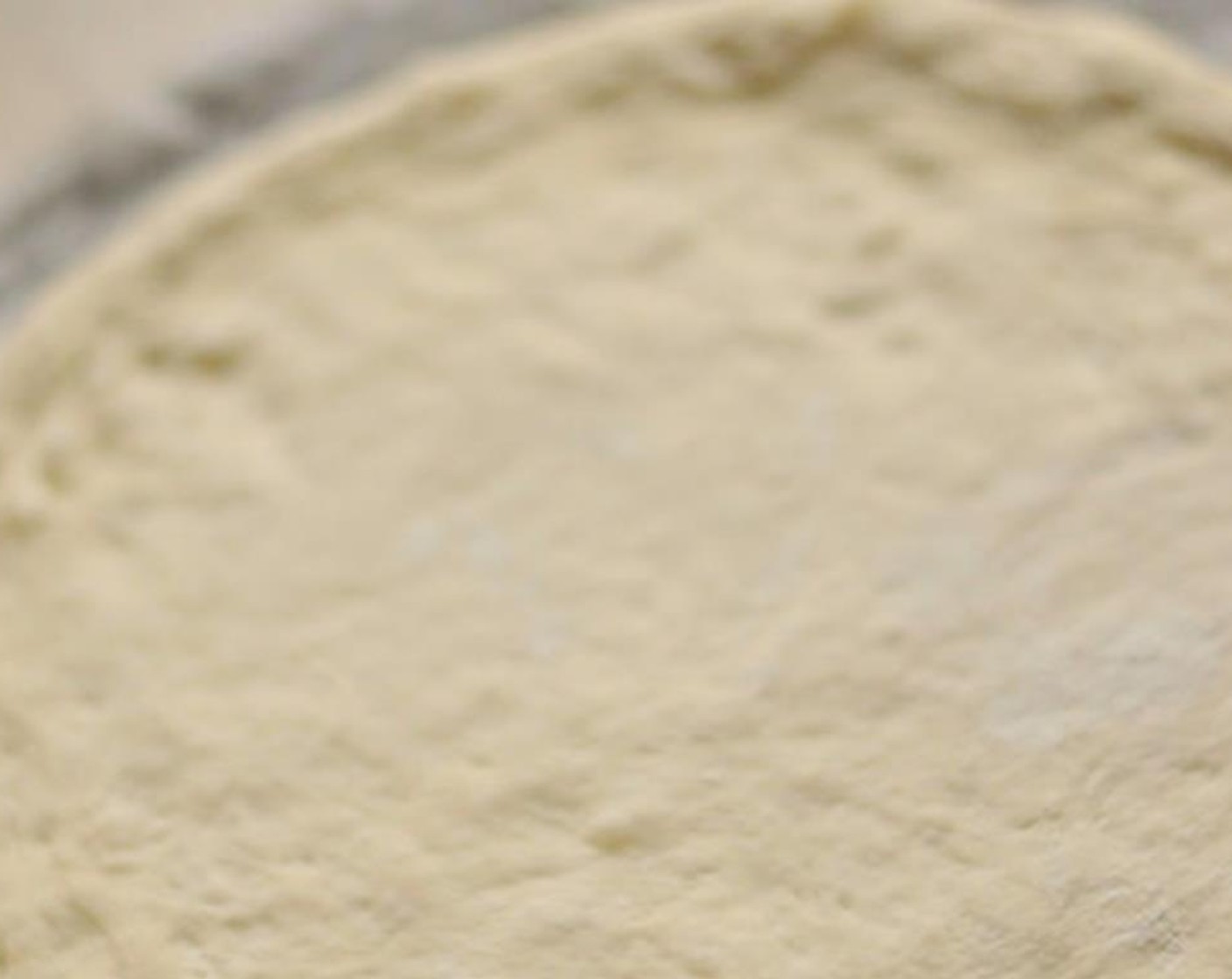 step 3 Put a piece of parchment paper on the cutting board and spray it with oil. Put the flattened pizza dough on top of the oiled parchment paper.