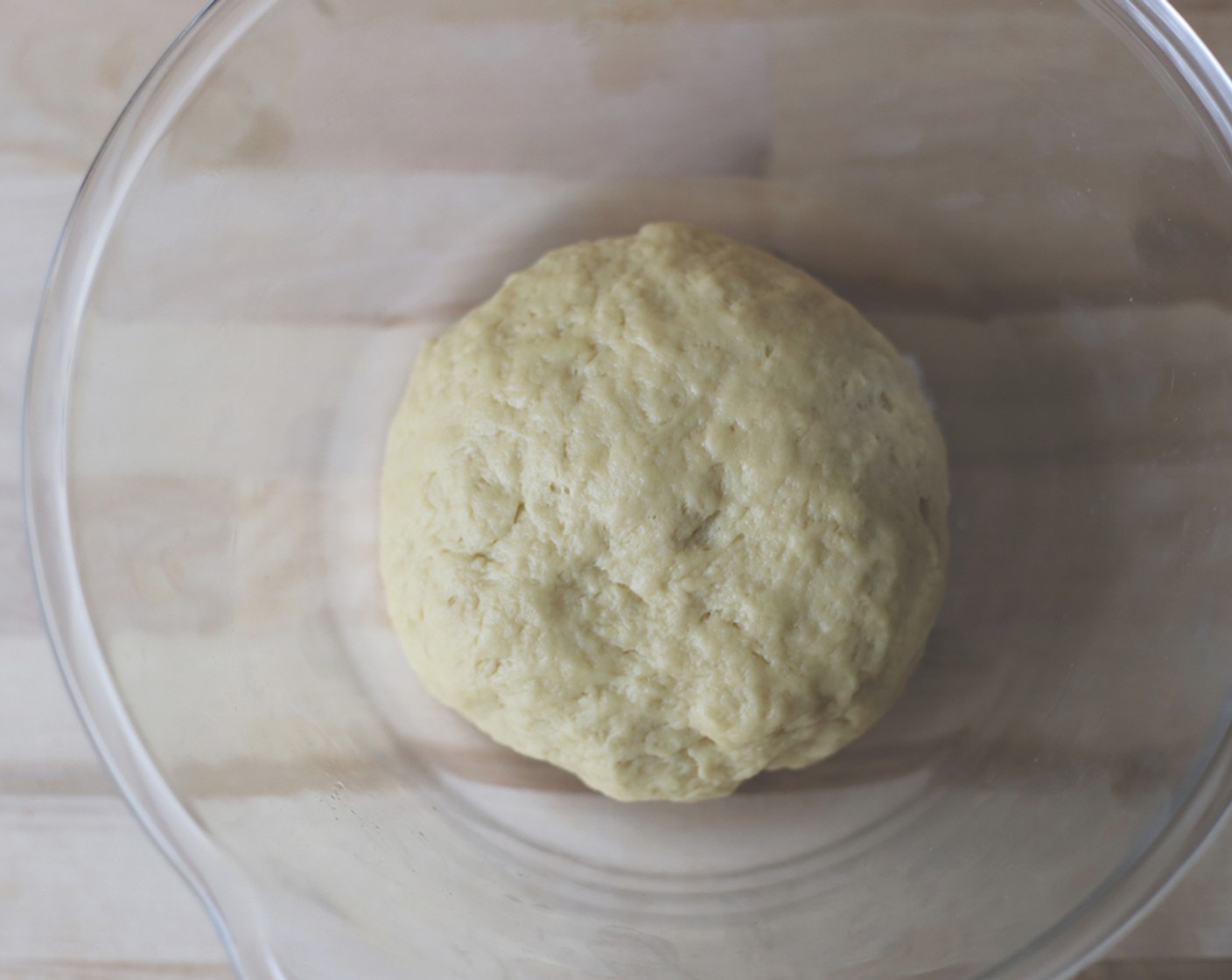 step 9 Turn the dough out on to a lightly-floured surface and knead with your hands until the dough is completely smooth. Place the dough in a greased bowl and cover with plastic wrap.