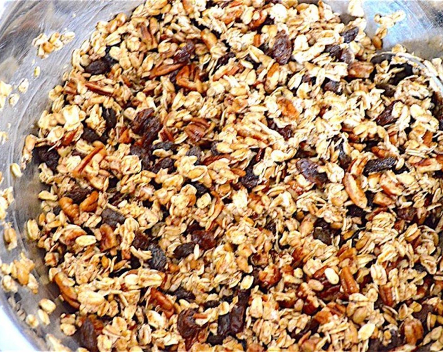 step 2 Combine the Old Fashioned Rolled Oats (3 cups), Chopped Pecans (1 1/2 cups), Raisins (1 1/2 cups), Shelled Sunflower Seeds (1 1/2 cups), Ground Cinnamon (1/2 Tbsp), Salt (1 pinch), Maple Syrup (3/4 cup), and Water (3/4 cup) in a large mixing bowl. Stir thoroughly until combined.