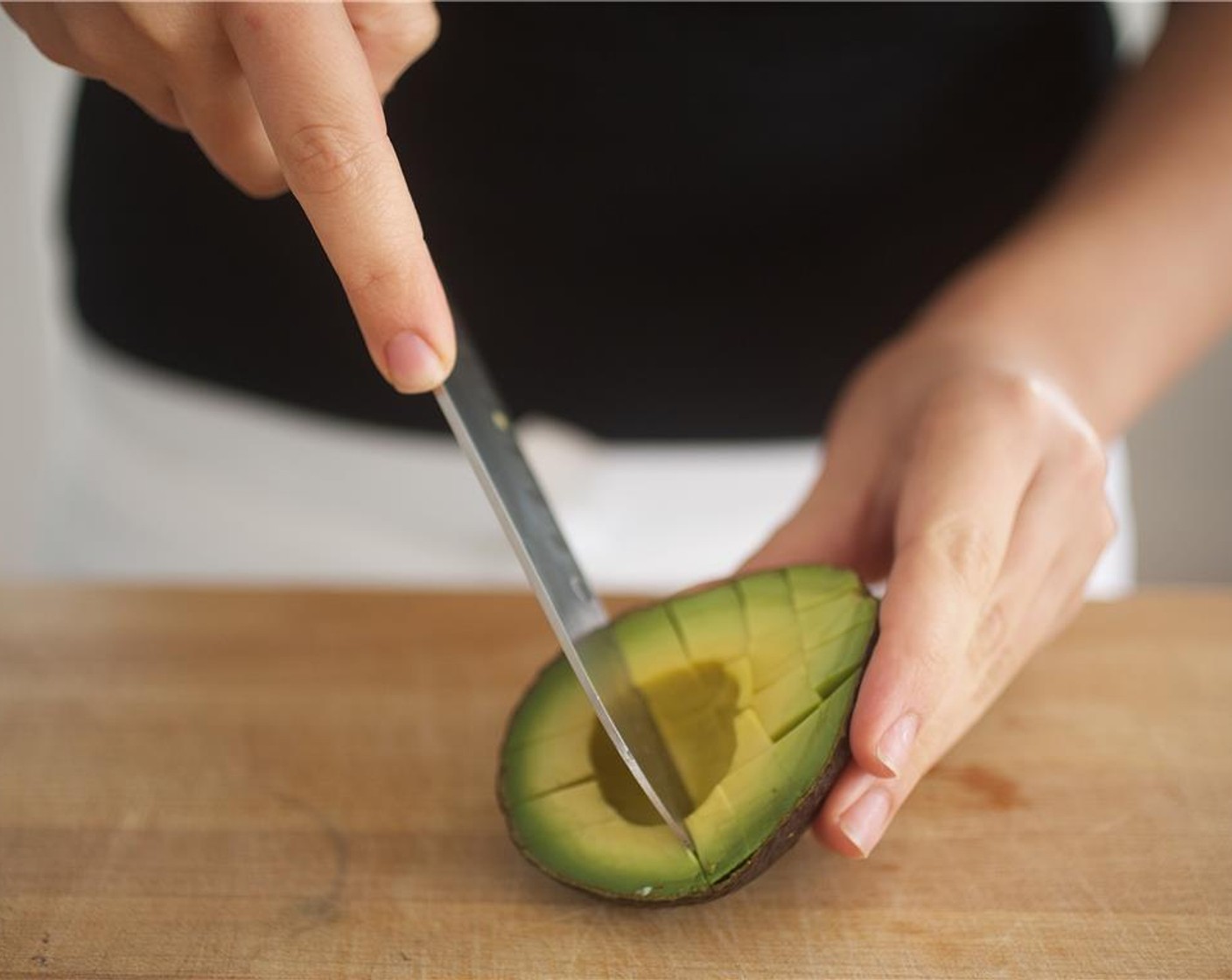 step 3 Remove the pit of the Avocado (1/2). Score avocado flesh without piercing the skin, making squares. Scoop out half of the avocado and place in a small bowl. Set aside.