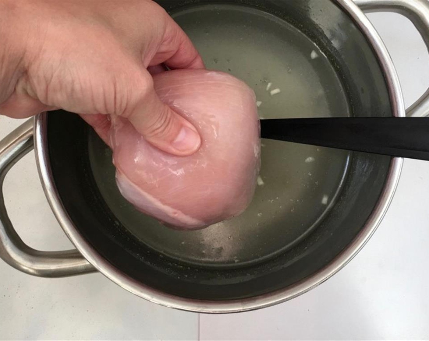 step 1 Pour the Chicken Stock (2 1/2 cups) in a high pan and add the Garlic (2 cloves). Bring the stock to a good boil over high heat and then add the Chicken Breasts (9 oz).